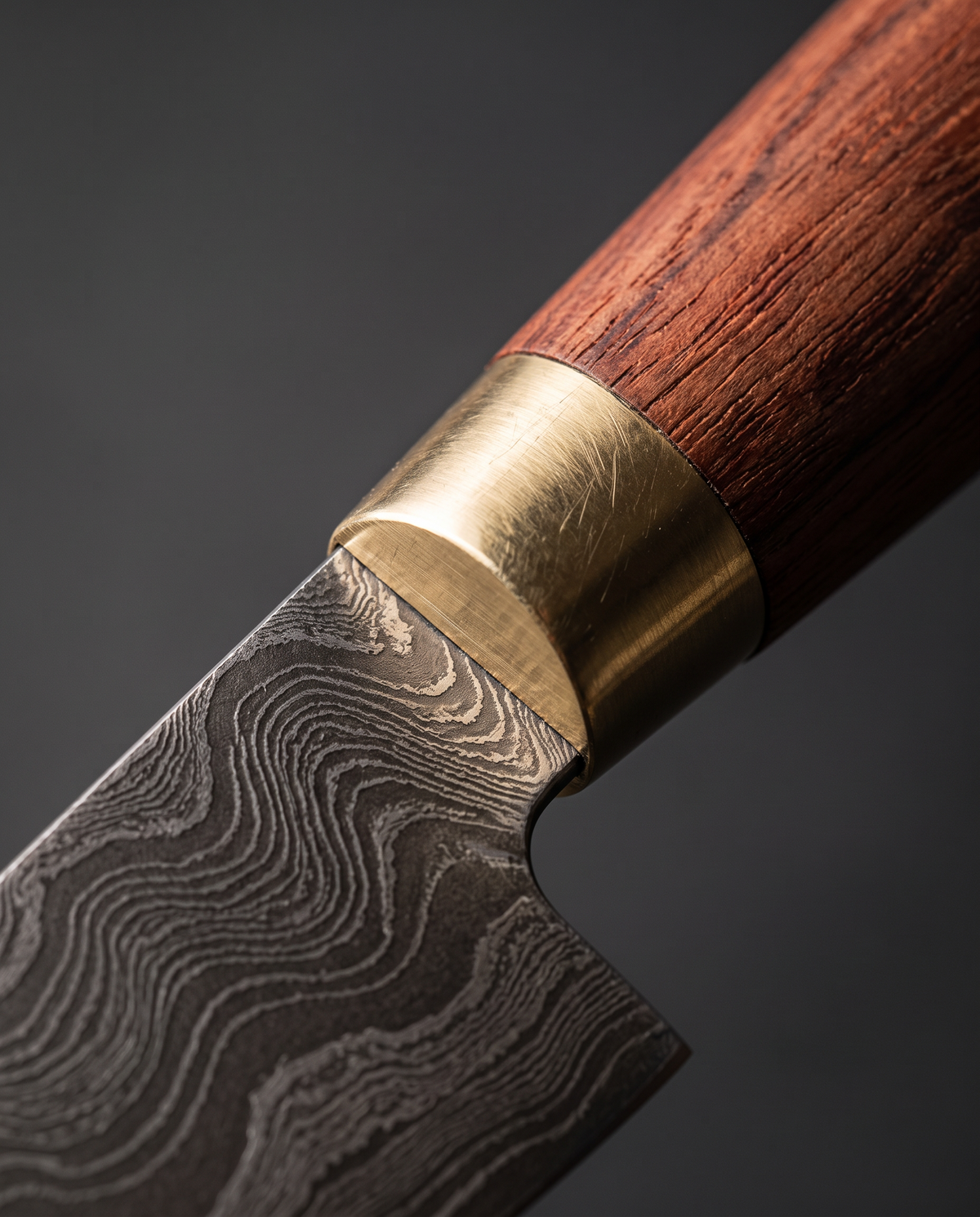 Manche en bois brun-rouge et bague laiton du Gyuto 200, à la jonction avec la lame damas